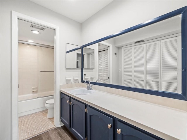 full bathroom featuring vanity, toilet, wood-type flooring, and tiled shower / bath combo