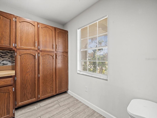 kitchen with decorative backsplash and light wood-type flooring