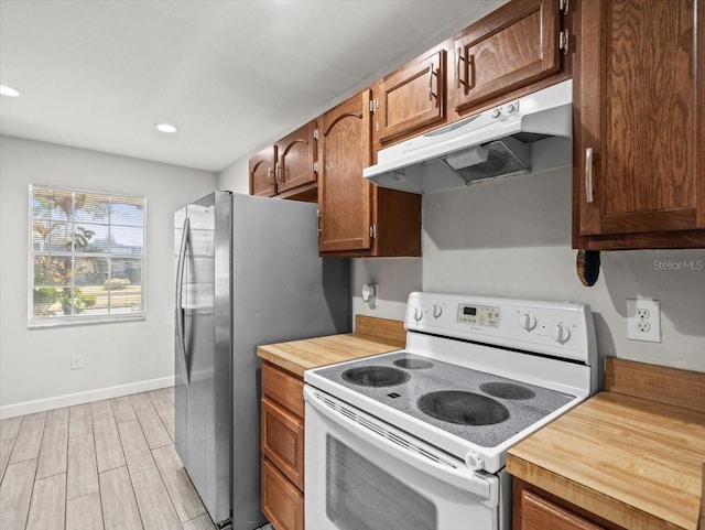 kitchen featuring stainless steel fridge, light wood-type flooring, and electric stove