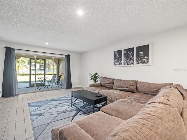 living room featuring light hardwood / wood-style flooring and a textured ceiling