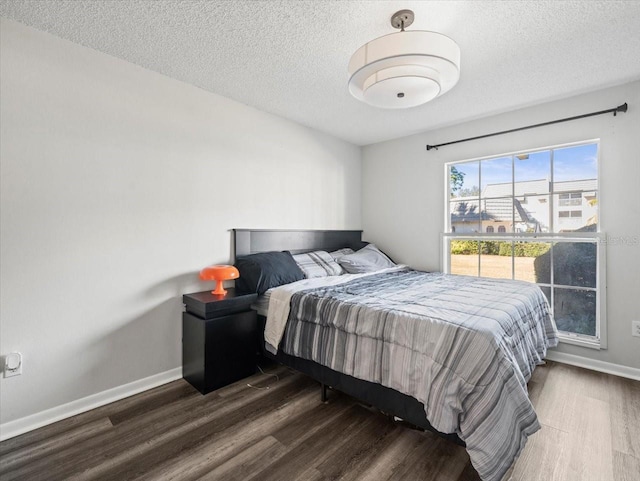 bedroom featuring a textured ceiling and dark hardwood / wood-style floors