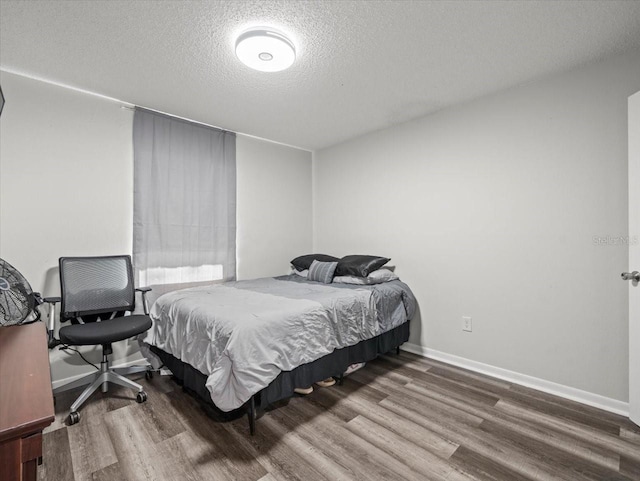 bedroom with a textured ceiling and hardwood / wood-style flooring