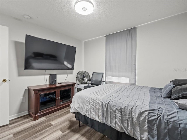 bedroom featuring a textured ceiling and hardwood / wood-style flooring