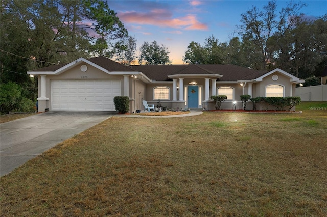 ranch-style house featuring a yard and a garage