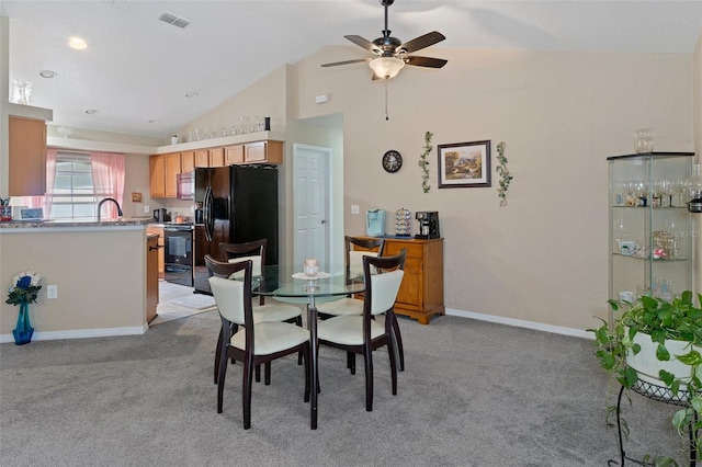 carpeted dining room with high vaulted ceiling and ceiling fan