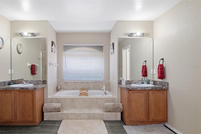 bathroom with hardwood / wood-style flooring, vanity, and a textured ceiling