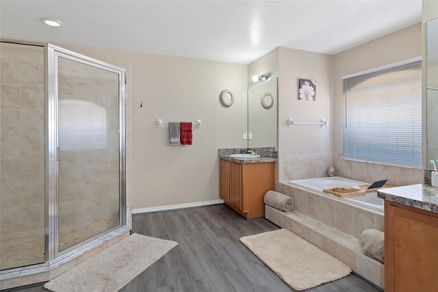 bathroom featuring hardwood / wood-style floors, a textured ceiling, and independent shower and bath