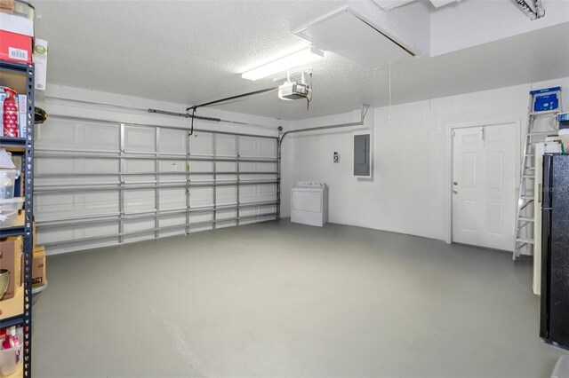 garage featuring washer / dryer, a garage door opener, and electric panel