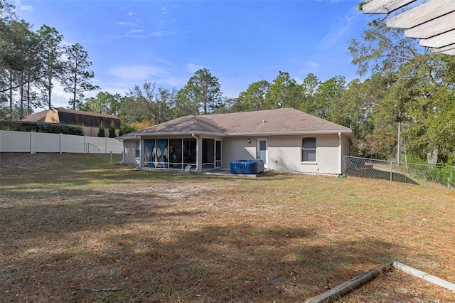 back of property with a sunroom and a lawn