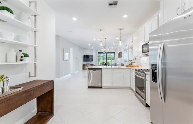 kitchen with white cabinetry, hanging light fixtures, stainless steel appliances, kitchen peninsula, and decorative backsplash