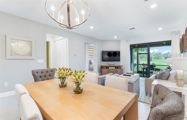 dining area with light tile patterned floors and an inviting chandelier