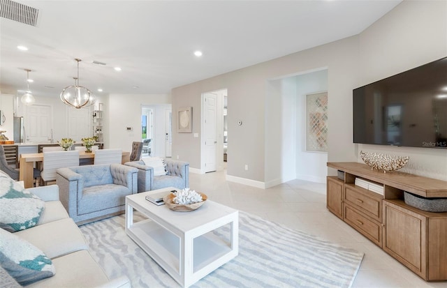 living room with light tile patterned floors and an inviting chandelier