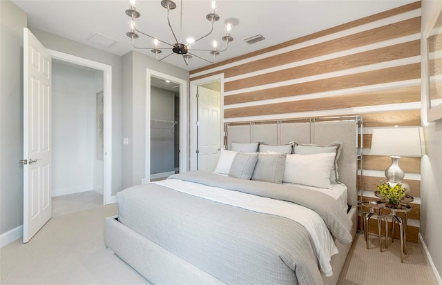 bedroom with a notable chandelier, light colored carpet, a spacious closet, and a closet