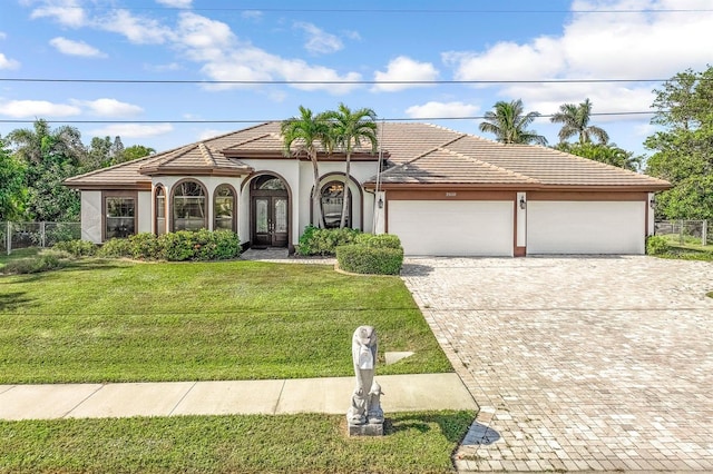 mediterranean / spanish home with a front yard and a garage