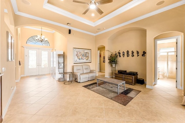 tiled living room featuring a raised ceiling, a wealth of natural light, and ornamental molding