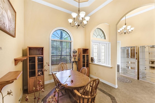 dining space featuring tile patterned flooring, ornamental molding, a high ceiling, and an inviting chandelier