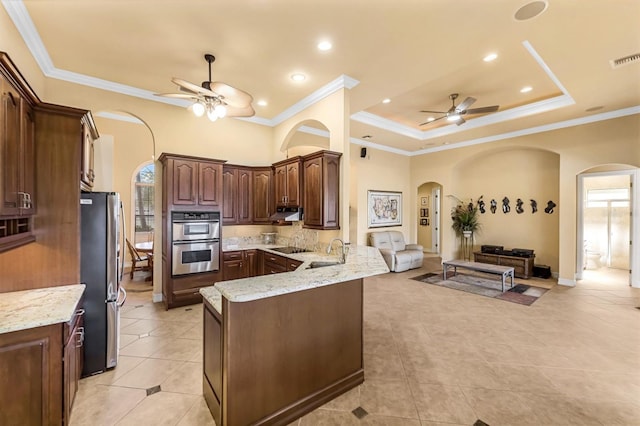 kitchen with sink, ceiling fan, ornamental molding, appliances with stainless steel finishes, and kitchen peninsula