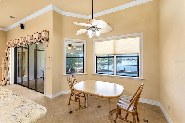 dining space featuring crown molding, ceiling fan, and light tile patterned floors