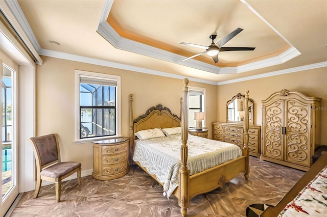 bedroom featuring a raised ceiling, multiple windows, and ceiling fan