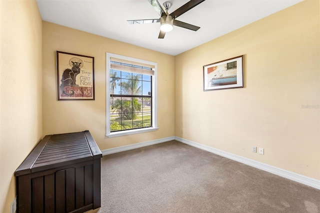 carpeted spare room with ceiling fan