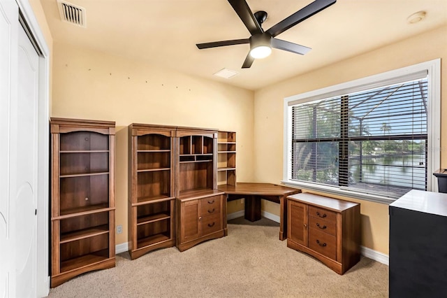 carpeted office space featuring ceiling fan