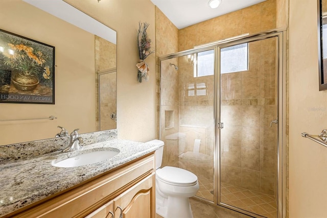 bathroom with tile patterned flooring, vanity, toilet, and walk in shower