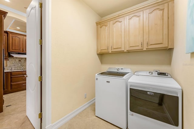 washroom with separate washer and dryer, light tile patterned floors, and cabinets