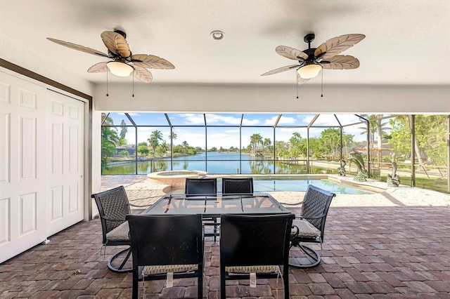 view of patio / terrace with a swimming pool with hot tub, a water view, glass enclosure, and ceiling fan