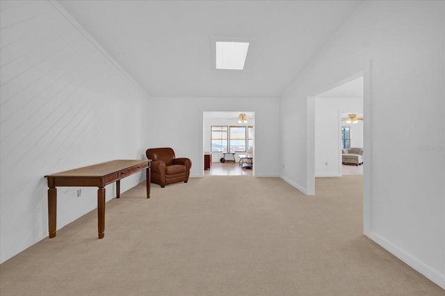 sitting room with light carpet, ceiling fan, and lofted ceiling with skylight