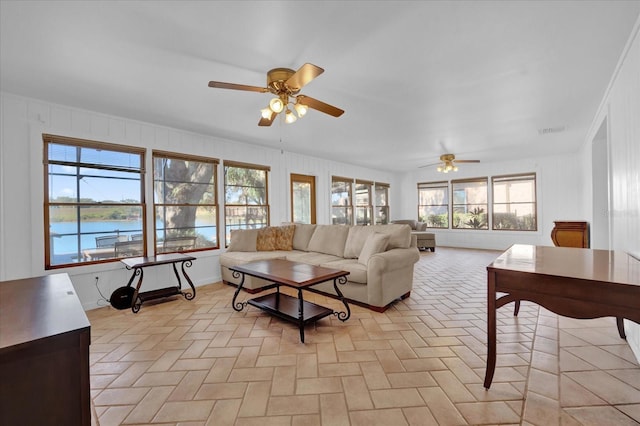 living room with a water view and ceiling fan