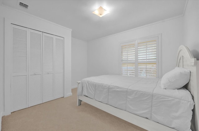 carpeted bedroom featuring a closet and crown molding