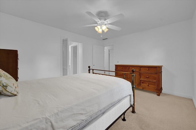 carpeted bedroom with ceiling fan and a closet