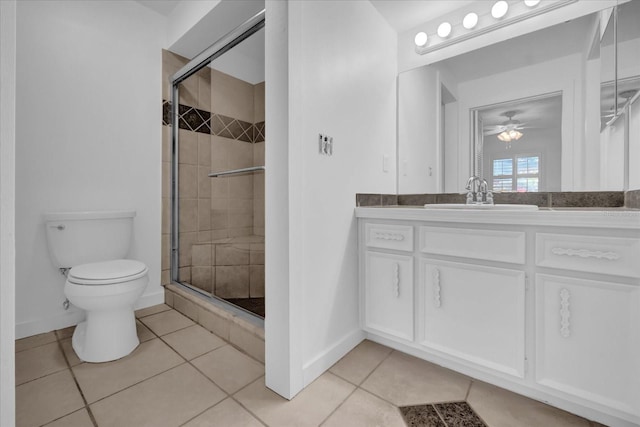 bathroom with toilet, tile patterned floors, a shower with door, and vanity