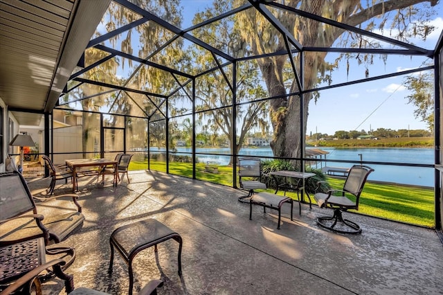 view of patio with a lanai and a water view