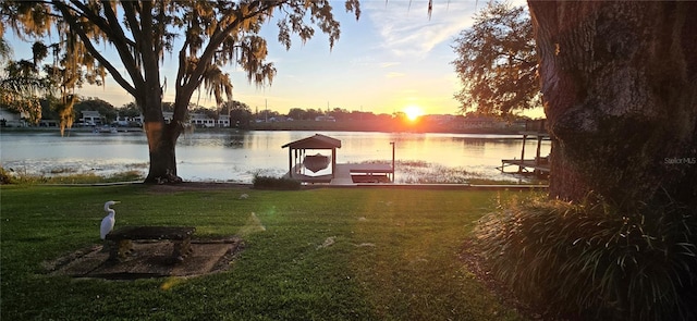 view of dock featuring a water view and a yard