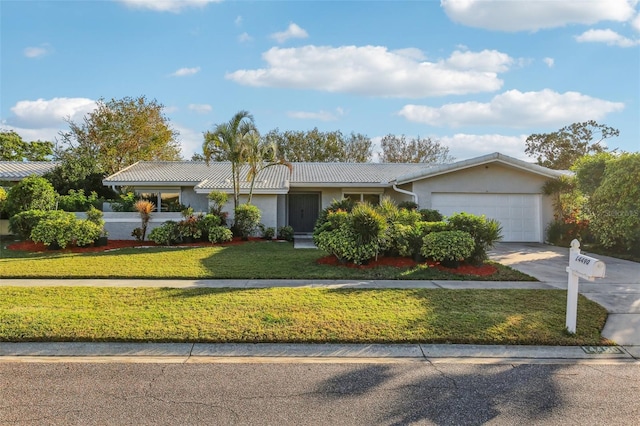 ranch-style home featuring a front lawn and a garage