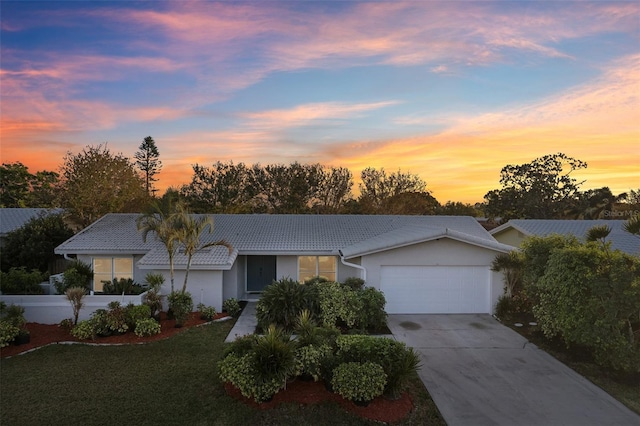 single story home featuring a lawn and a garage