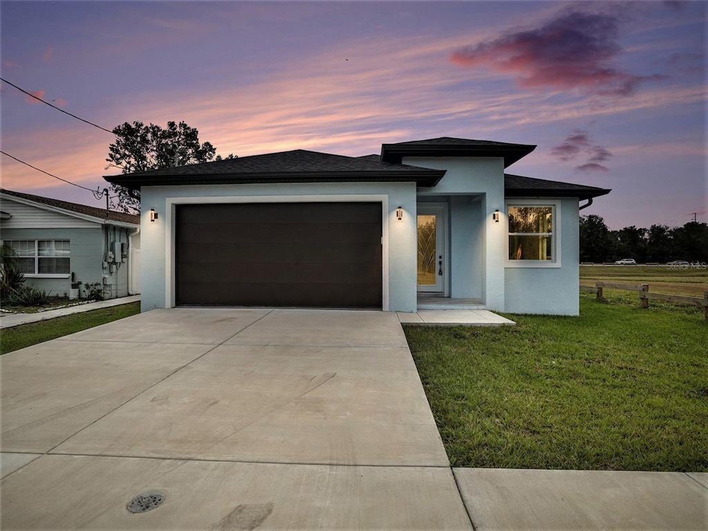 view of front of property with a garage and a lawn