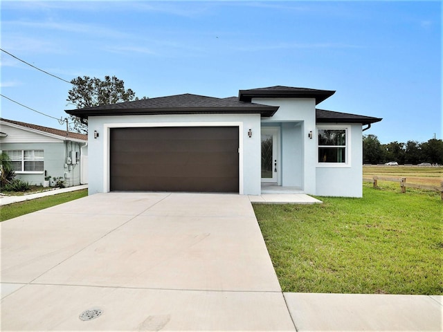 prairie-style home with a garage and a front yard