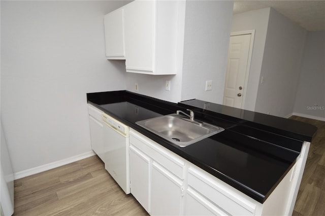 kitchen featuring white dishwasher, white cabinets, sink, light hardwood / wood-style floors, and kitchen peninsula