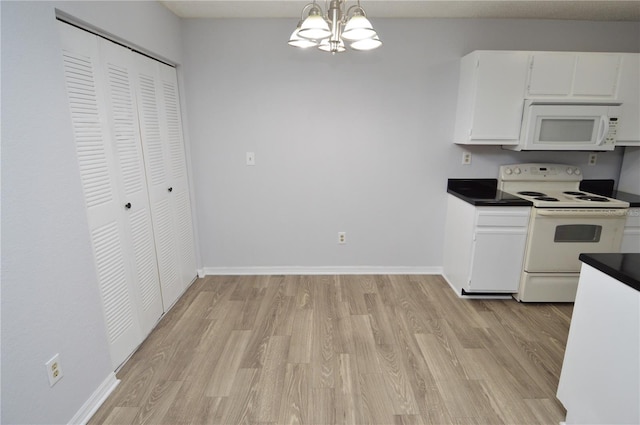 kitchen featuring white appliances, an inviting chandelier, white cabinets, hanging light fixtures, and light wood-type flooring