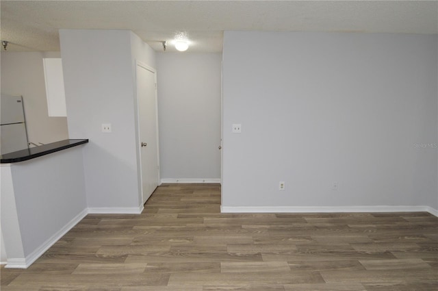 unfurnished room with wood-type flooring and a textured ceiling