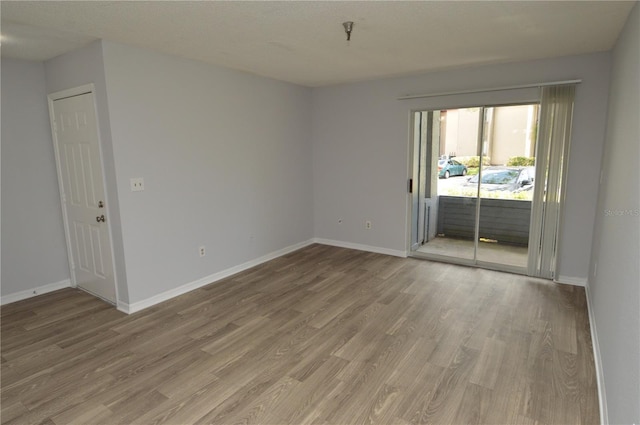 empty room with wood-type flooring and a textured ceiling