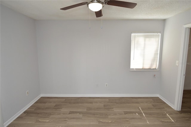 spare room featuring hardwood / wood-style floors, ceiling fan, and a textured ceiling