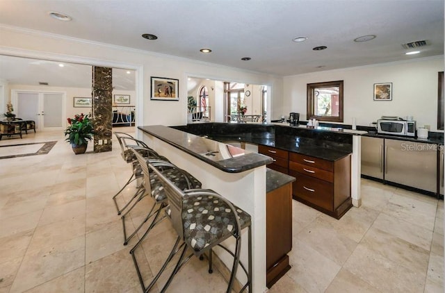 kitchen featuring a breakfast bar, a center island, and crown molding