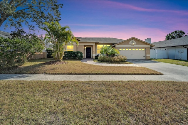 ranch-style home featuring a yard and a garage