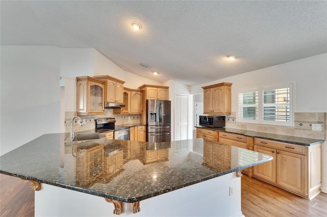 kitchen with sink, stainless steel appliances, a kitchen breakfast bar, vaulted ceiling, and kitchen peninsula