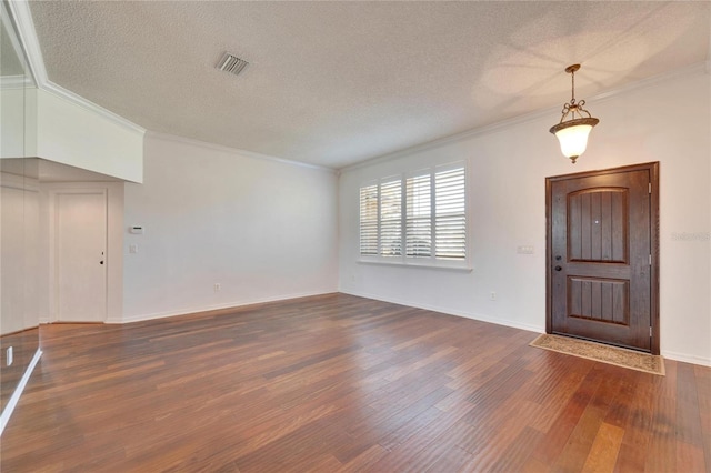 interior space featuring crown molding, dark wood-type flooring, and a textured ceiling