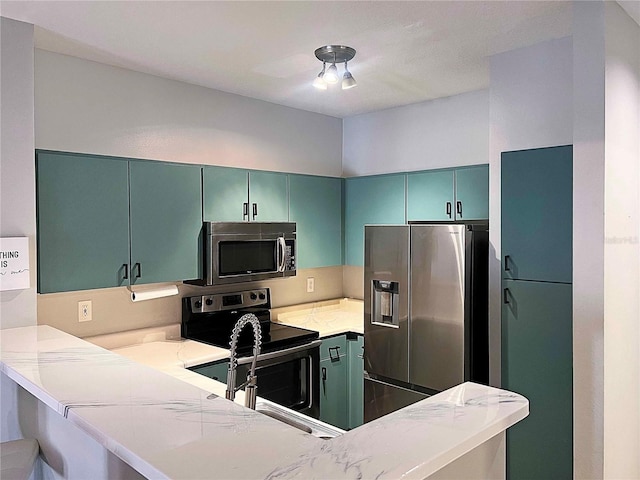 kitchen with kitchen peninsula, light stone counters, and stainless steel appliances