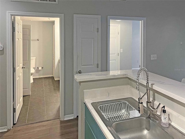 bathroom with toilet, wood-type flooring, and sink